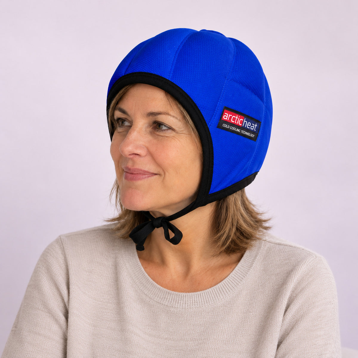 Mujer con el gorro frío Arctic Heat azul puesto, atado bajo la barbilla