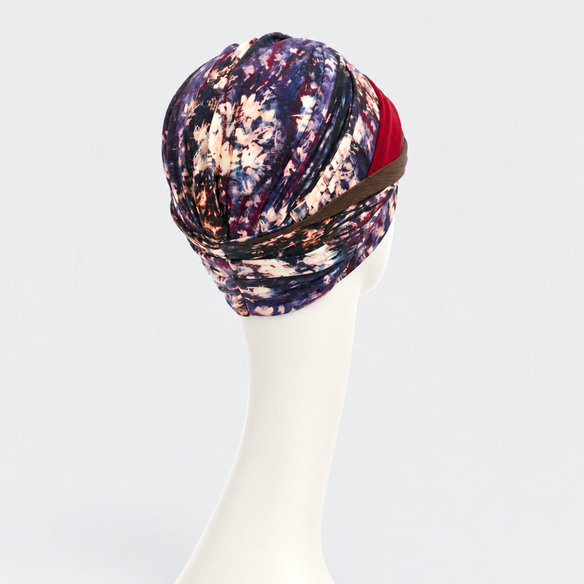 Vista posterior del turbante Shakti Tie Dye Dusk de Christine Headwear, con estampado en tonos azul, burdeos y crema.